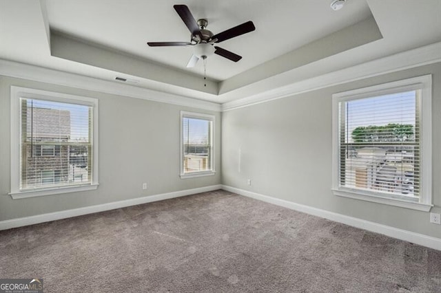 unfurnished room with ceiling fan, ornamental molding, a tray ceiling, and carpet floors