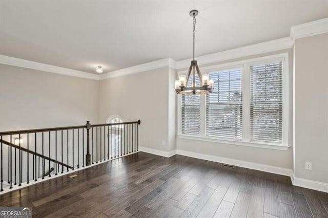 empty room with ornamental molding, dark hardwood / wood-style floors, and a notable chandelier