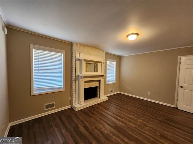 unfurnished living room with ornamental molding, dark hardwood / wood-style flooring, and a fireplace