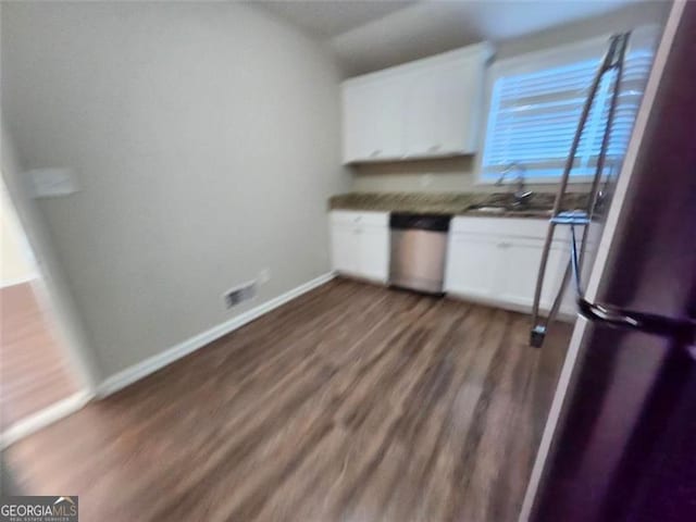 kitchen featuring appliances with stainless steel finishes, dark hardwood / wood-style flooring, white cabinetry, and vaulted ceiling