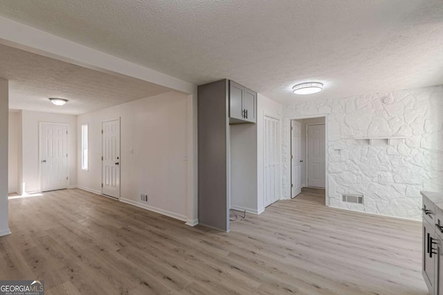 empty room featuring a textured ceiling and light wood-type flooring