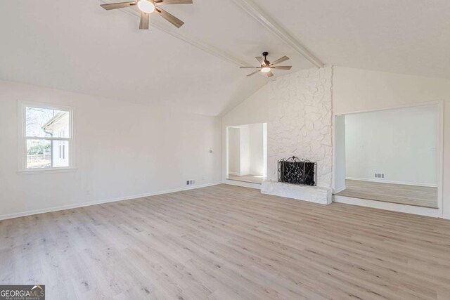 unfurnished living room featuring a fireplace, lofted ceiling with beams, ceiling fan, and light hardwood / wood-style flooring