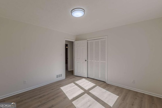 unfurnished bedroom with a closet and light hardwood / wood-style flooring