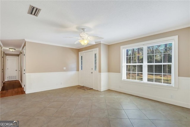 unfurnished room with ornamental molding, ceiling fan, and light tile patterned flooring