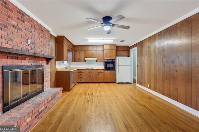 kitchen featuring a fireplace, ornamental molding, and black appliances