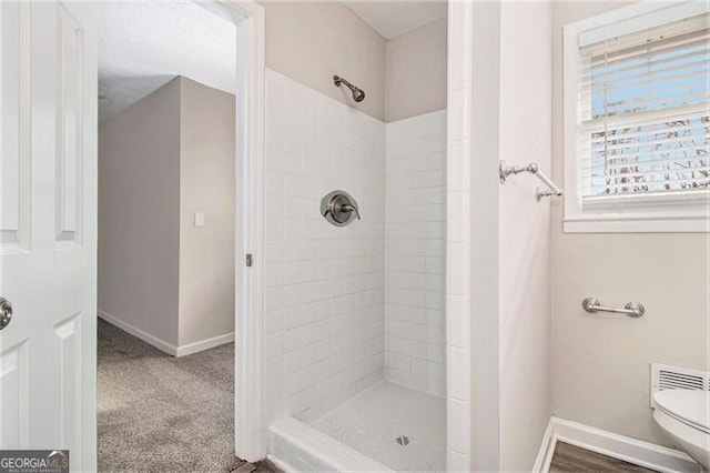 bathroom featuring toilet and tiled shower