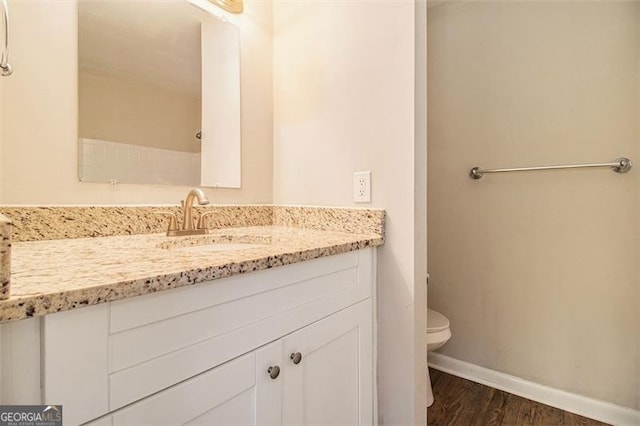 bathroom featuring toilet, wood-type flooring, and vanity