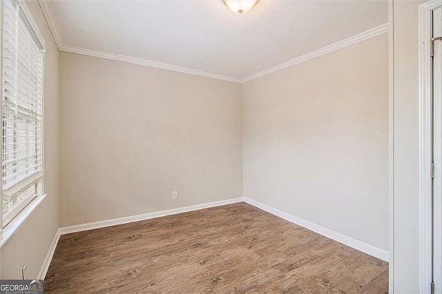 empty room featuring wood-type flooring and crown molding