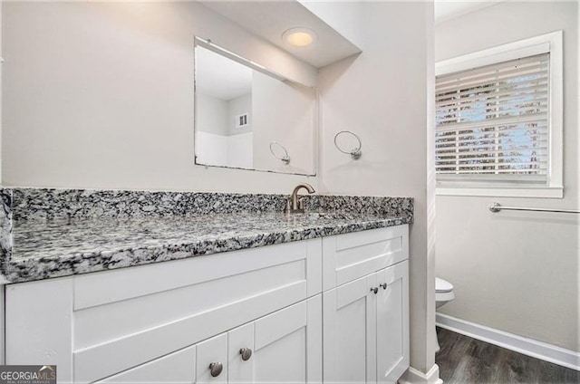 bathroom featuring wood-type flooring, vanity, and toilet