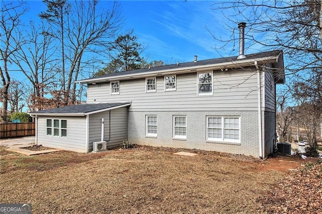 back of property featuring a yard and central AC