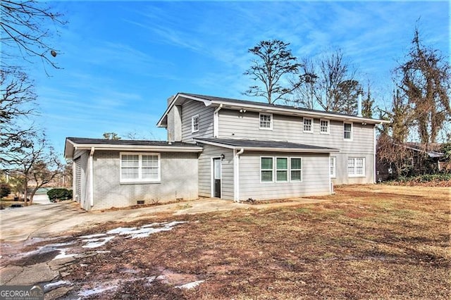 rear view of property featuring a lawn