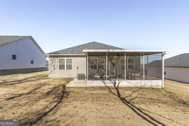 back of house with central AC, a sunroom, and a lawn