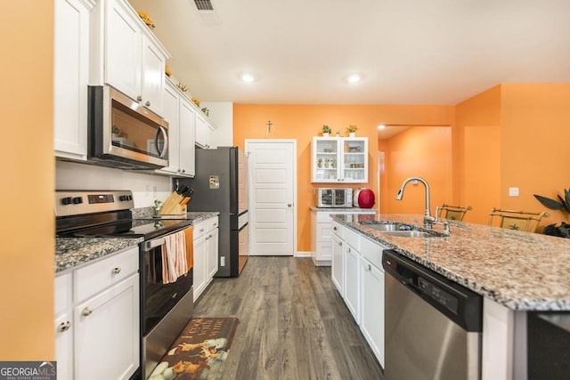 kitchen featuring appliances with stainless steel finishes, white cabinetry, dark hardwood / wood-style flooring, and sink