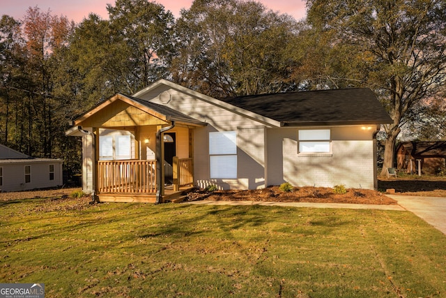 single story home featuring covered porch and a lawn