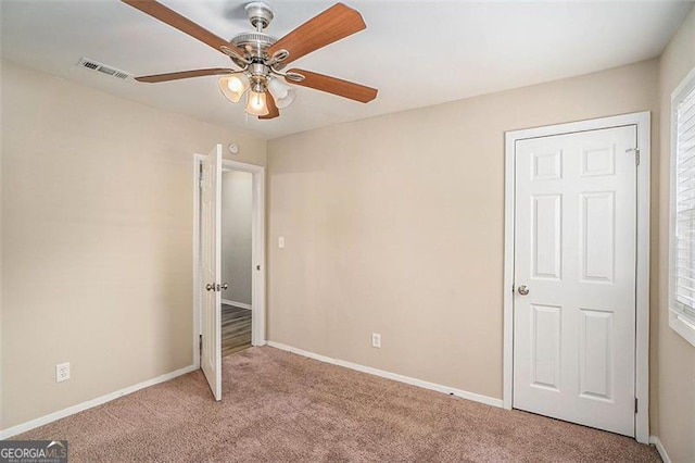 unfurnished bedroom featuring ceiling fan and light carpet