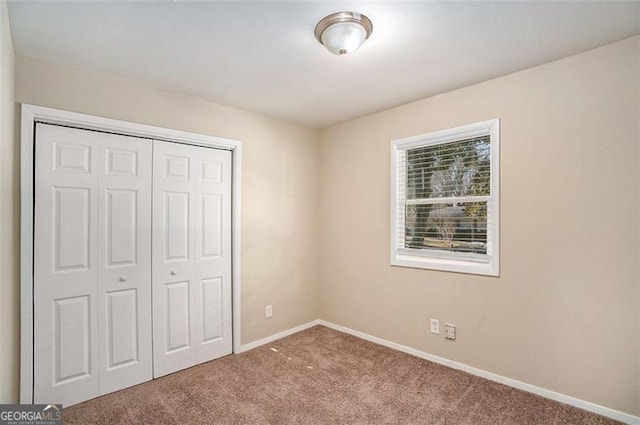 unfurnished bedroom with a closet and light carpet