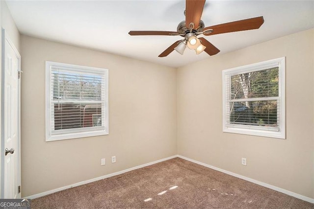 spare room featuring a healthy amount of sunlight, ceiling fan, and carpet flooring