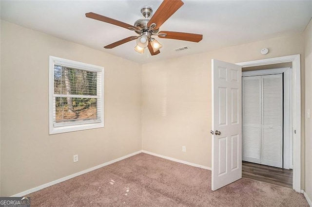 unfurnished bedroom featuring carpet floors, ceiling fan, and a closet