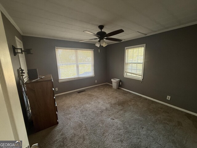 carpeted empty room featuring ceiling fan and ornamental molding