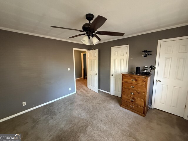 unfurnished bedroom with ceiling fan, crown molding, and carpet floors