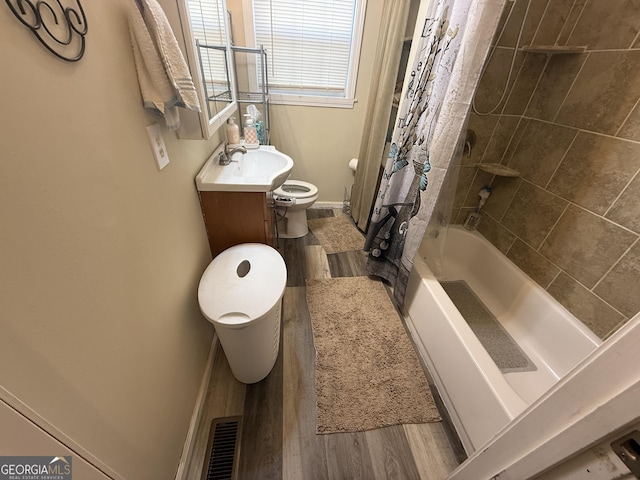 full bathroom featuring toilet, vanity, hardwood / wood-style floors, and shower / bath combo with shower curtain