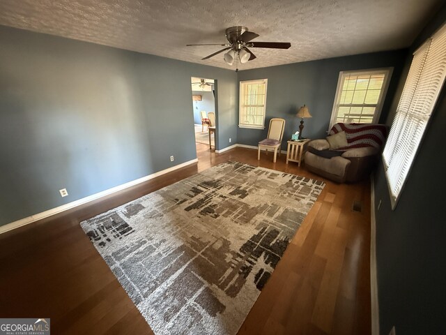 sitting room with a textured ceiling, ceiling fan, and hardwood / wood-style floors