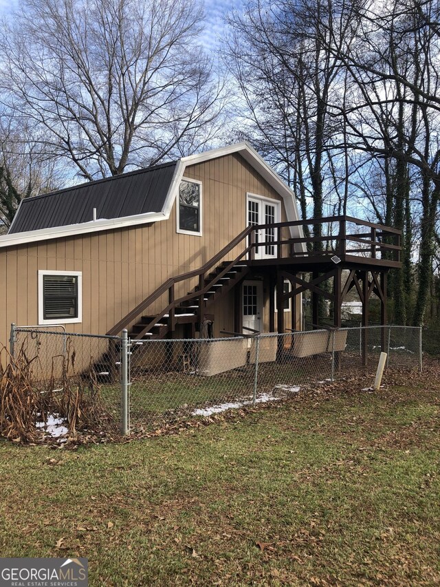 view of side of property featuring a yard and a wooden deck