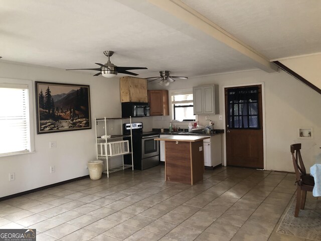 kitchen featuring ceiling fan, stainless steel range with electric cooktop, a kitchen island, and light tile patterned floors