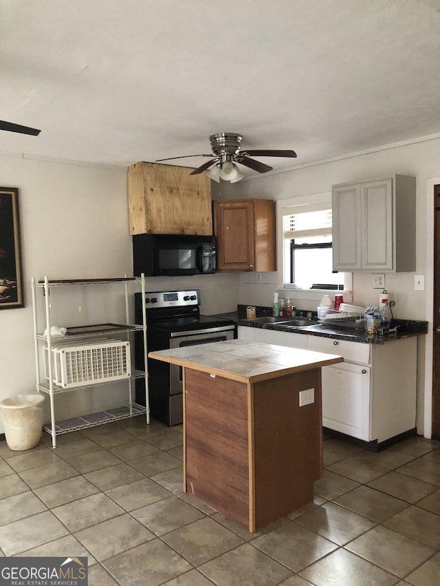 kitchen featuring tile patterned floors, a center island, ceiling fan, and electric stove