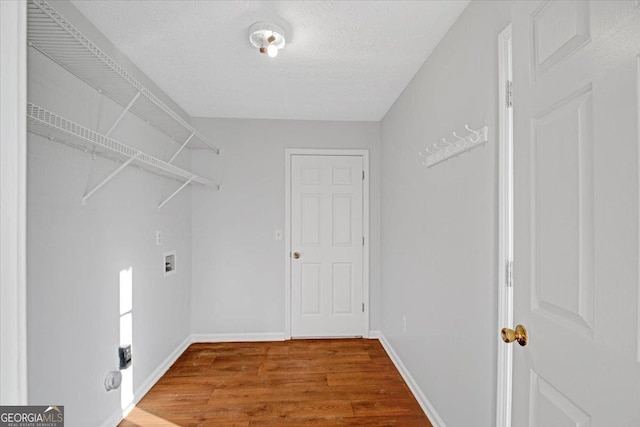 laundry room with wood-type flooring, washer hookup, and a textured ceiling