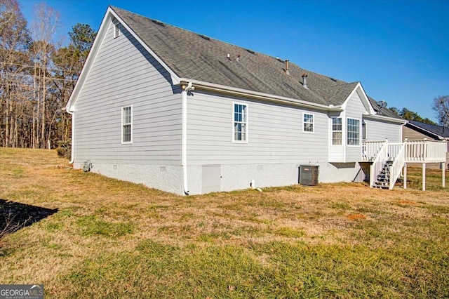 back of property with a lawn, central AC unit, and a deck