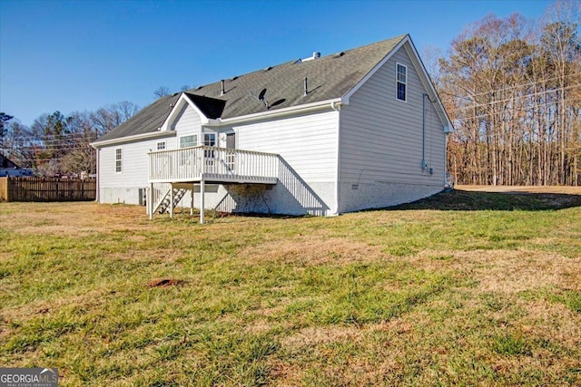 rear view of house featuring a deck and a yard