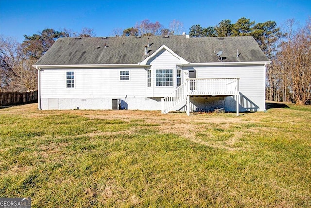 rear view of property with a wooden deck, a lawn, and central AC