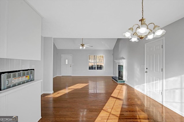 living room with lofted ceiling, a fireplace, ceiling fan with notable chandelier, and dark hardwood / wood-style floors