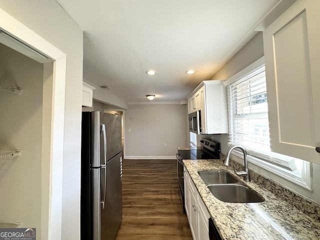 kitchen with sink, white cabinets, light stone counters, dark hardwood / wood-style floors, and appliances with stainless steel finishes