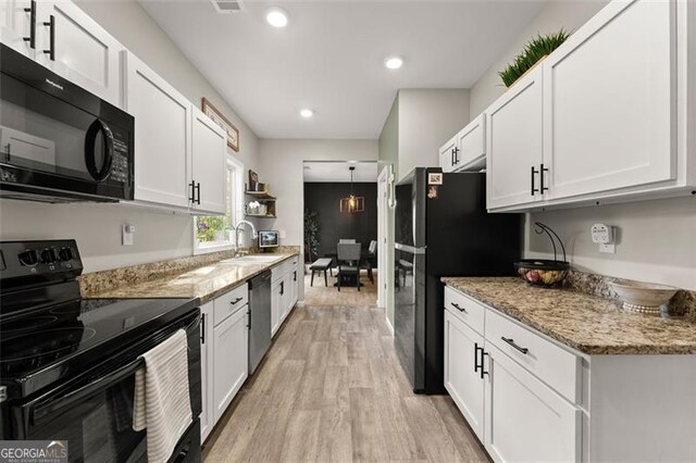 kitchen featuring black appliances, hanging light fixtures, light hardwood / wood-style floors, white cabinets, and sink