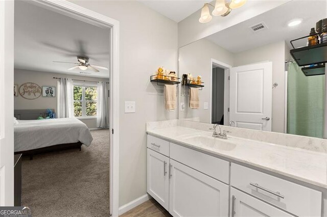 bathroom featuring hardwood / wood-style flooring, ceiling fan, and vanity