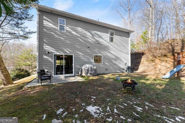 back of property with a fire pit, central AC, a patio, and a lawn