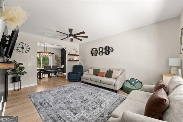 living room featuring ceiling fan and light wood-type flooring