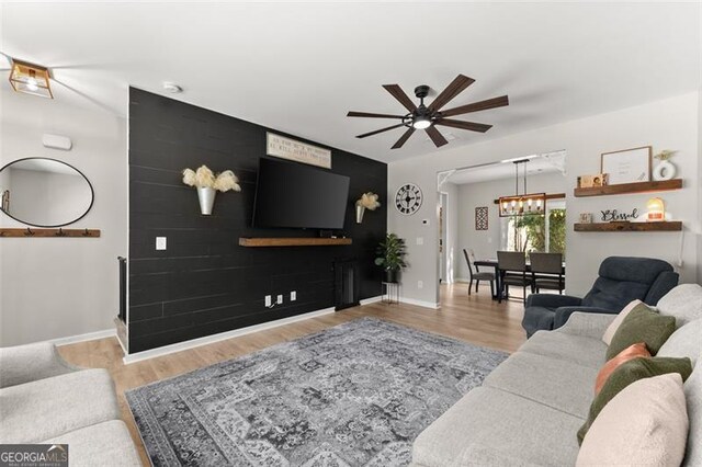 living room featuring ceiling fan and light hardwood / wood-style flooring