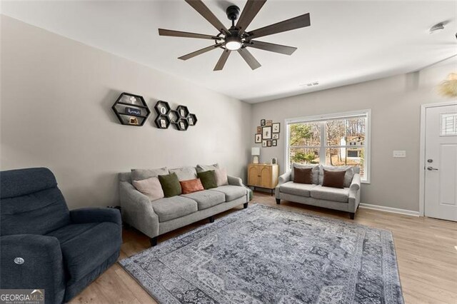 living room with light wood-type flooring and ceiling fan