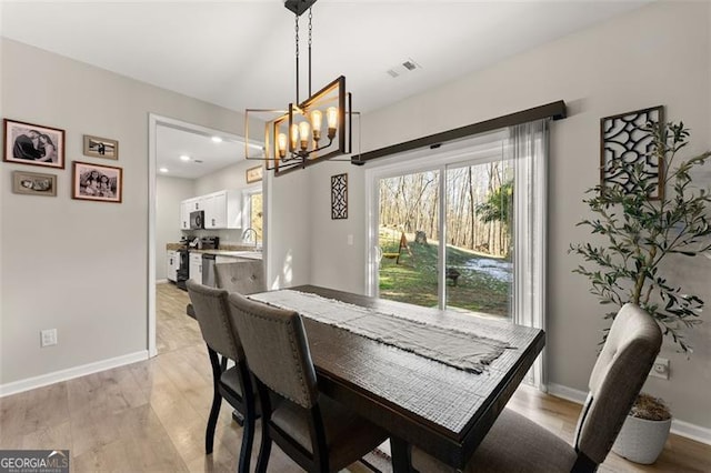 dining space featuring recessed lighting, visible vents, baseboards, light wood-style floors, and an inviting chandelier