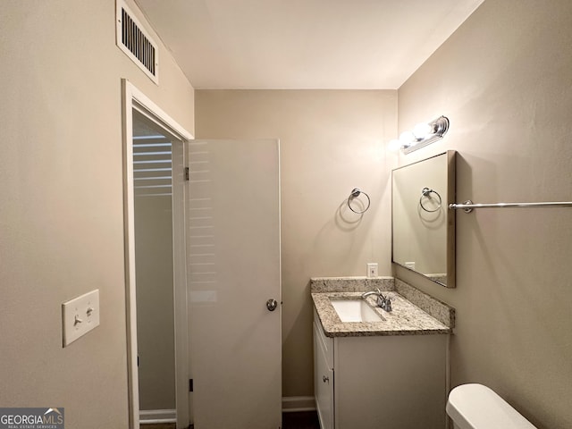 bathroom featuring toilet and vanity