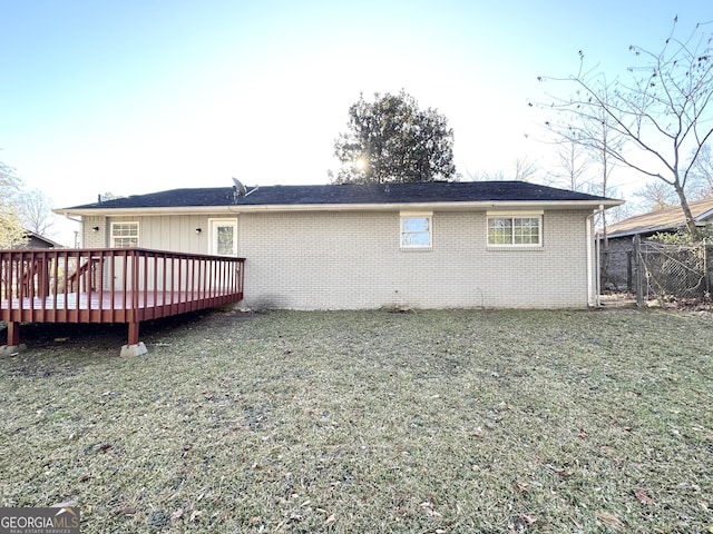 rear view of house featuring a yard and a wooden deck