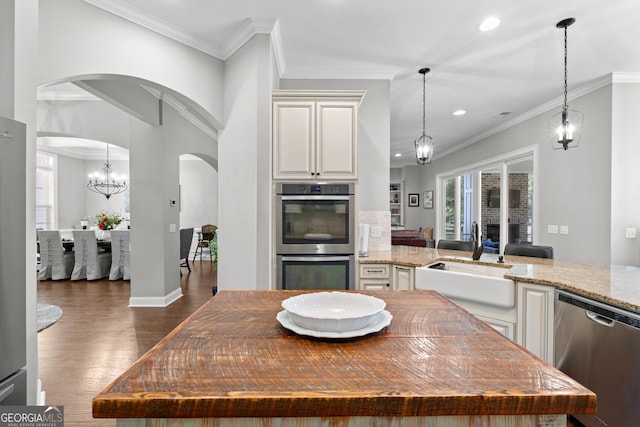 kitchen featuring a kitchen island, stainless steel appliances, light stone countertops, and sink