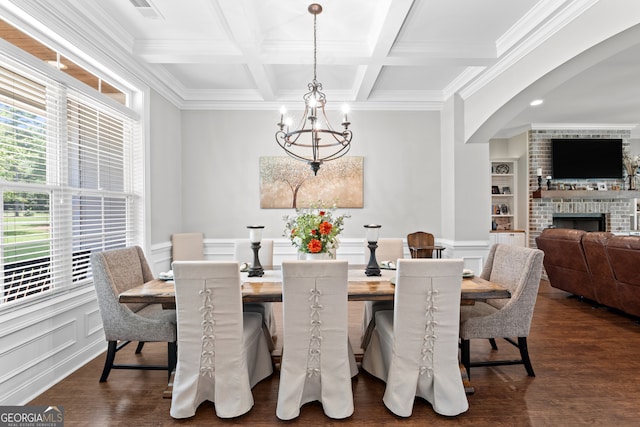 dining room with a chandelier, built in shelves, beam ceiling, a fireplace, and coffered ceiling