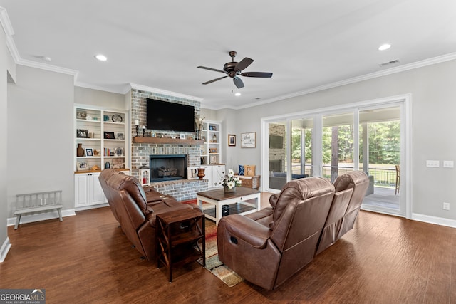 living room featuring ornamental molding, ceiling fan, dark hardwood / wood-style flooring, and a brick fireplace