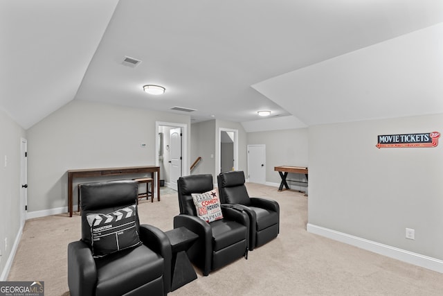 cinema with light colored carpet and vaulted ceiling