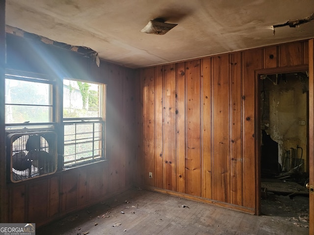 empty room with a healthy amount of sunlight and wooden walls