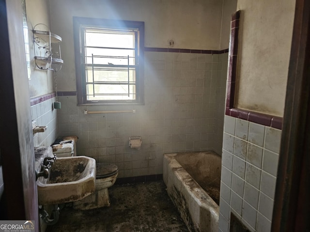 bathroom featuring toilet, tile walls, sink, and a bath